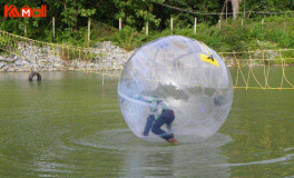 pink zorb ball played in shallow water